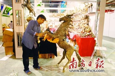 26日，海絲博覽會展館內(nèi)，外國參展商正在加緊布置展位。圖為緬甸參展商正在擦拭他們的展品。